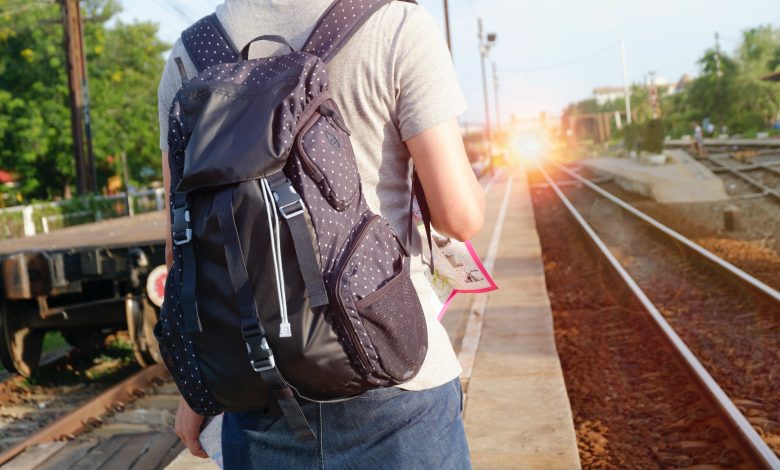 man on train station with backpack